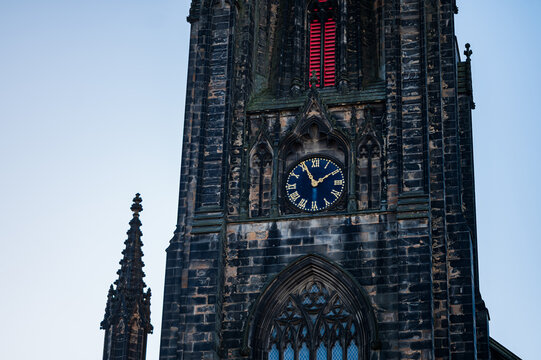 Edinburgh clock tower with blue face at evening