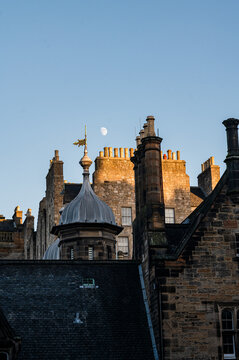 Moon above historic Edinburgh rooftops at sunset