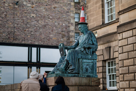 Statue with traffic cone hat in historic city street