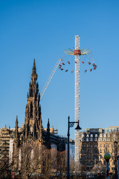 Swing ride beside Scott Monument under blue Edinburgh sky