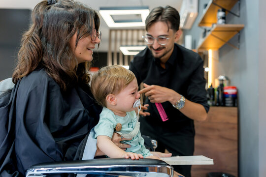 Child receives first haircut at a modern barbershop