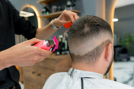 Barber trim man's hair with clipper in barbershop