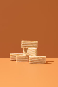 Cream-filled wafer cookies stacked on orange background