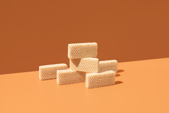 Cream-filled wafer cookies on orange background