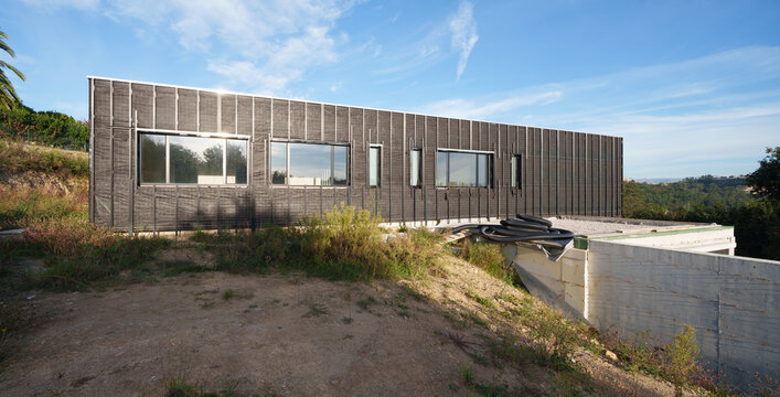 Modern house construction with unfinished facade and windows