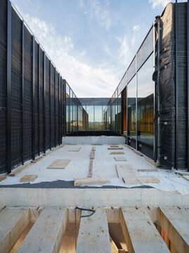 Modern house construction with glass walls and foundation