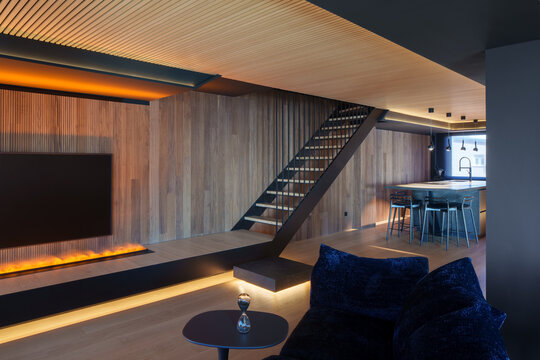 Modern coastal wooden interior with staircase and fireplace
