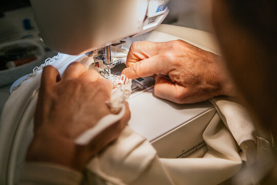 Dressmaker sew handmade garment in workshop with machine