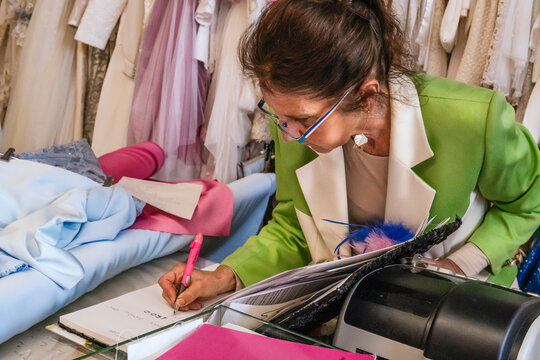 Dressmaker write order note in fabric workshop