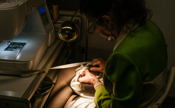 Dressmaker trim thread with scissors at sewing workshop