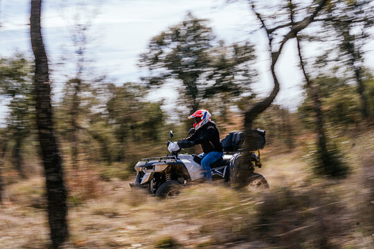 Quad rider enjoy off-road adventure through forest trail