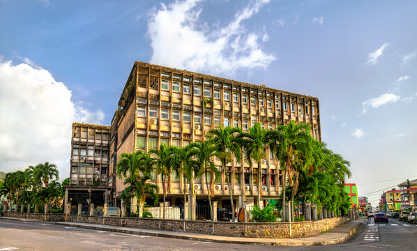 Brutalist style concrete building of Dominica Government Headquarters with palm trees in Roseau, Dominica.