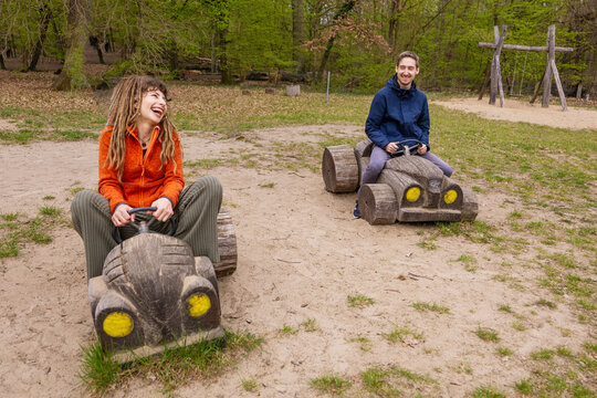 Couple enjoy wooden toy cars together in a park