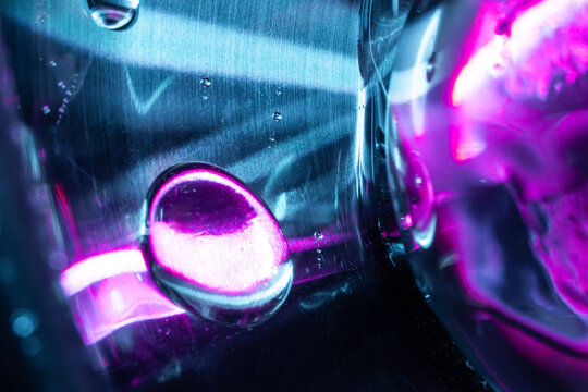Neon liquid droplet on futuristic glass tech background