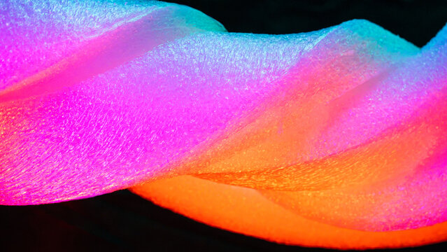 Vibrant neon fabric texture with abstract flowing folds
