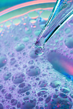 Macro petri dish with pipette and colorful liquid droplet