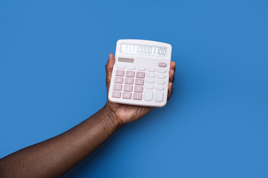 Black man hand holding calculator on blue background