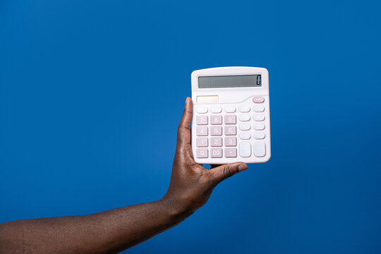 Black man hand hold calculator against blue background