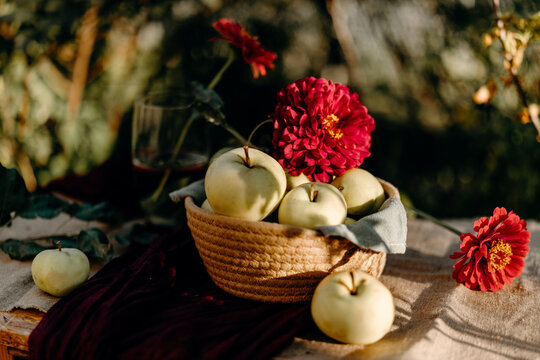 Still life of apple and dahlia in woven basket