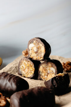 Chocolate-covered date confection with walnut filling close-up