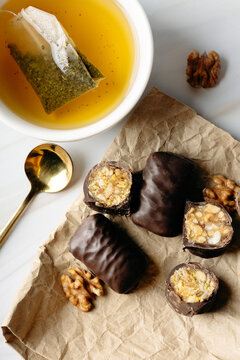 Herbal tea with dark chocolate walnut sweets close-up