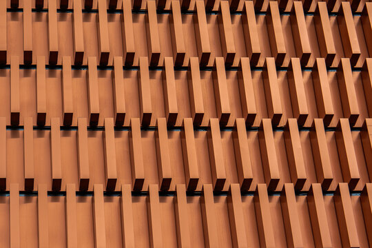 Geometric facade detail with repeating terracotta louvers
