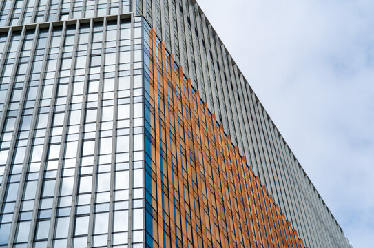 Modern high-rise facade with glass and orange panels