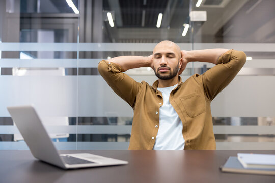Workplace burnout and stress relief, man taking a break at office desk with laptop