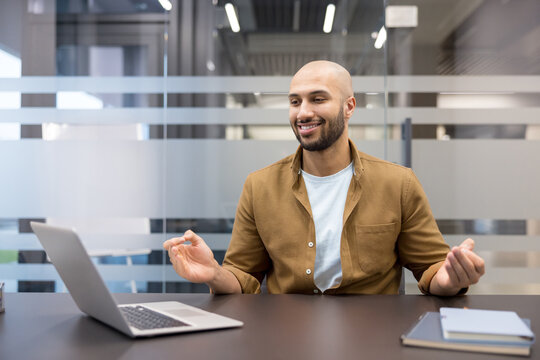 Mindfulness at work and stress relief, smiling man practicing meditation and breathing exercises in modern office during remote work break