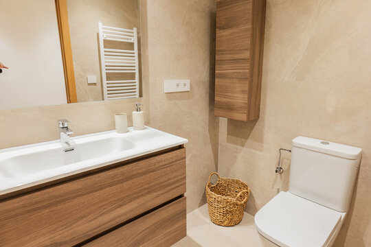 Modern apartment bathroom with wood vanity and toilet