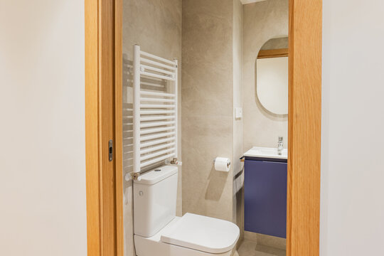 Modern apartment bathroom with oval mirror and vanity