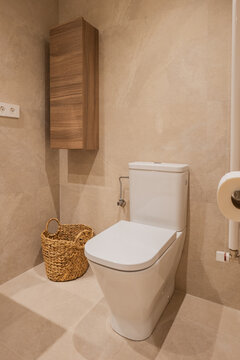 Modern apartment bathroom with toilet and wooden cabinet