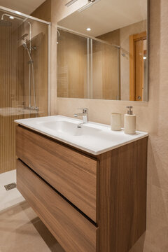 Modern apartment bathroom with wood vanity and glass shower