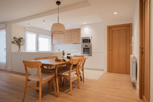 Modern apartment kitchen and dining area with wood furniture