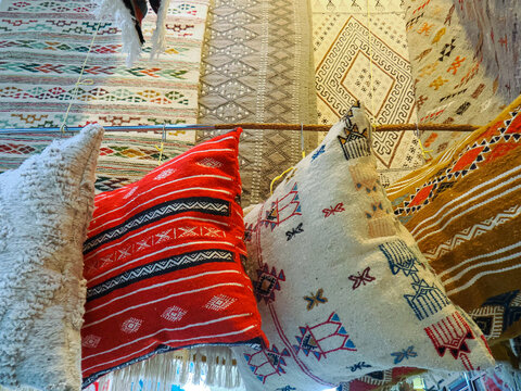 Pile of colorful handmade pillows and pillow case presented in traditional suq market in north african islamic Tunisia. 