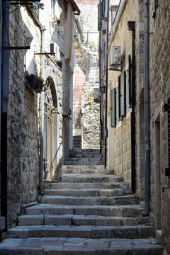 Narrow stone staircase in a sunlit historic alley