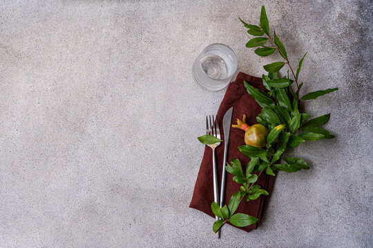 Autumnal pomegranate table set with foliage and cutlery