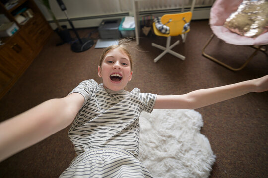 Joyful girl held aloft indoors with outstretched arms