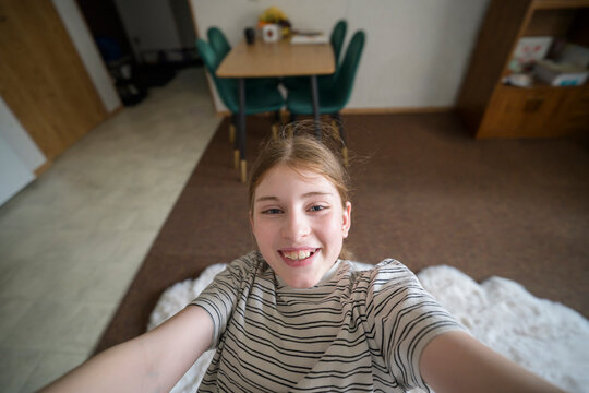 Smiling girl take selfie at home from high angle