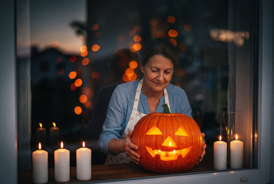 Woman with jack-o-lantern and candle at Halloween