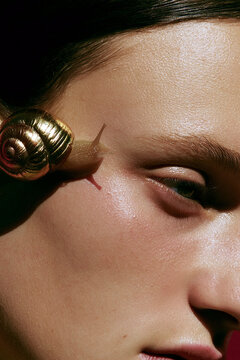 Creative beauty portrait with snail for skincare concept