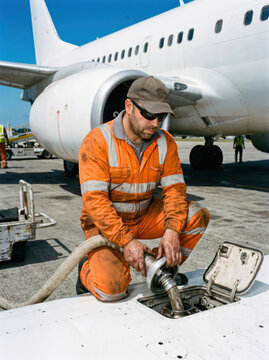 Engineer inspecting a fuel panel under a wing