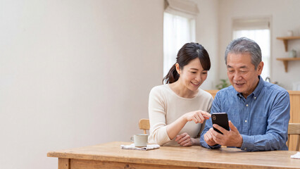 Obraz premium 若い女性からスマートフォンの使い方を教わるシニア男性