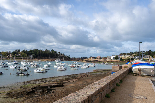 Ploumanach harbor filled with boats under cloudy sky in Brittany, France