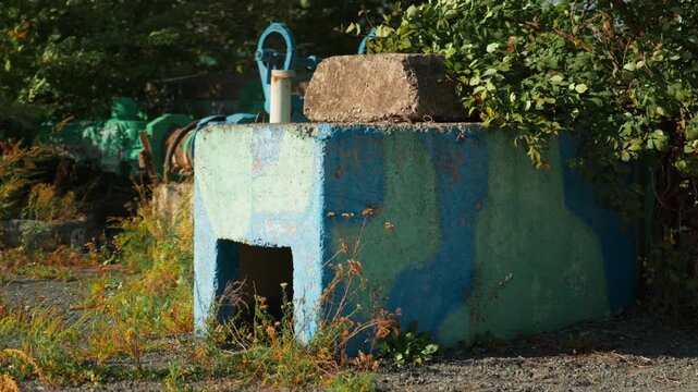 A concrete military defensive structure stands amidst the natural landscape.