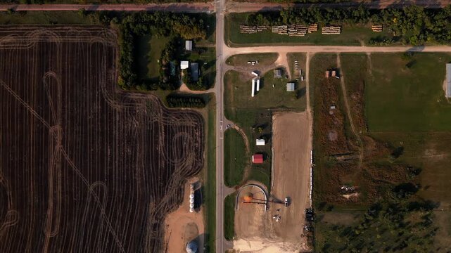 Top down aerial of a farmyard beside a ploughed field in Kansas