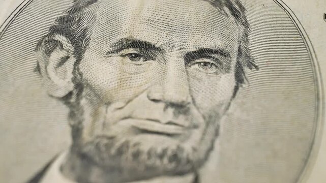United States five dollar bill featuring Abraham Lincoln portrait. Classic design reflects historical importance of American heritage. Intricate patterns enhance visual appeal of currency production