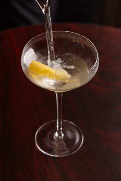 Pouring a classic Vesper Martini in to a martini coupe glass with a slow shutter speed showing motion.
