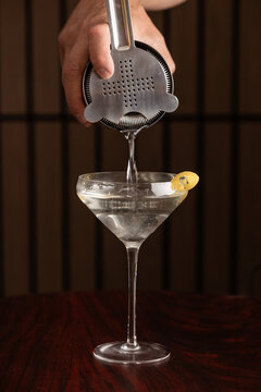 Pouring a classic Vesper Martini in to a martini coupe glass with a slow shutter speed showing motion.
