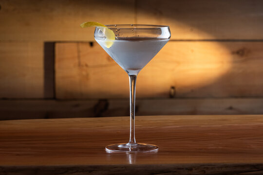The classic Vesper Martini, served in a modern coupe glass on a wooden background.